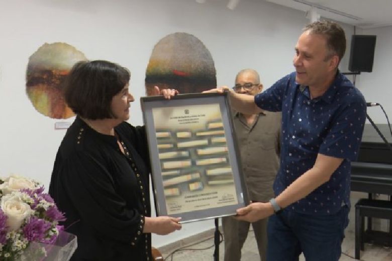 El presidente de la UNEAC, Luis Morlote Rivas, entrega el premio a la documentalista uruguaya.